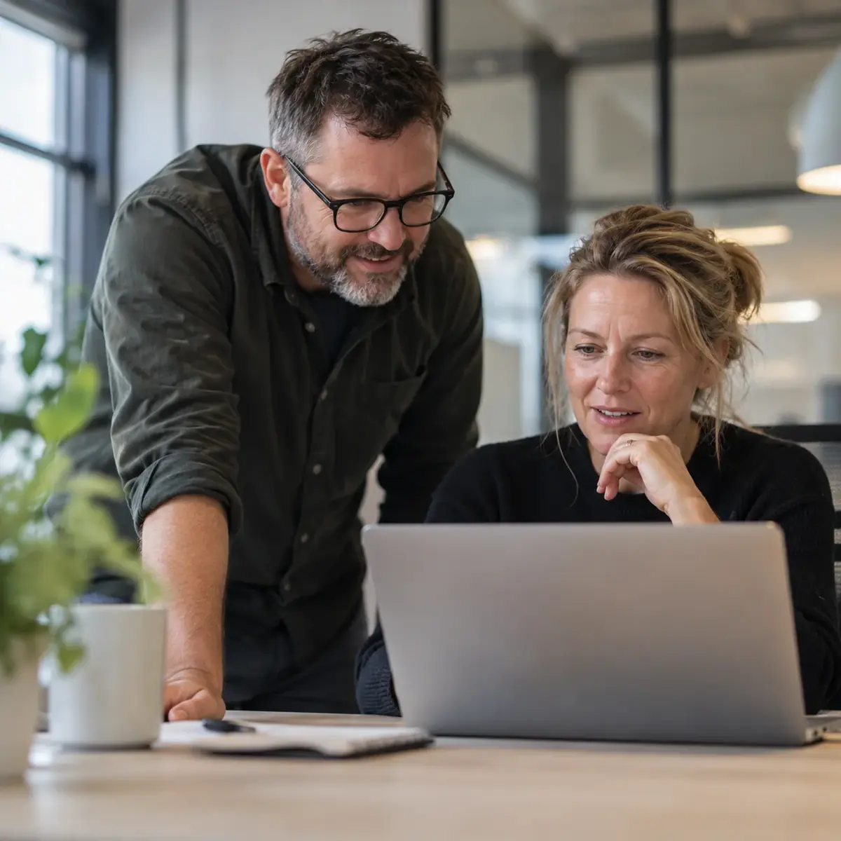 Two colleagues reviewing something together on a laptop